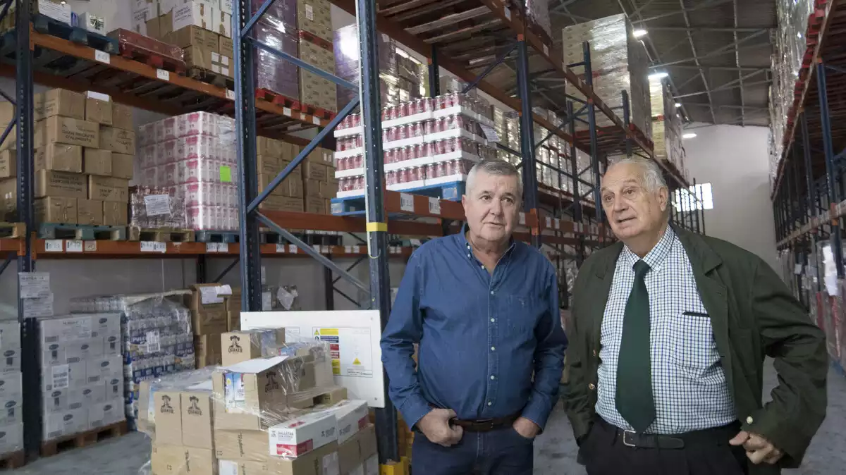 Joan Vila i Eusebio Alonso, membres del Banc d'Aliments, al magatzem de Reus
