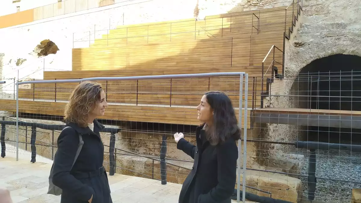 Laia Estrada i Eva Miguel al davant de la grada instal·lada a la plaça dels Sedassos de Tarragona.