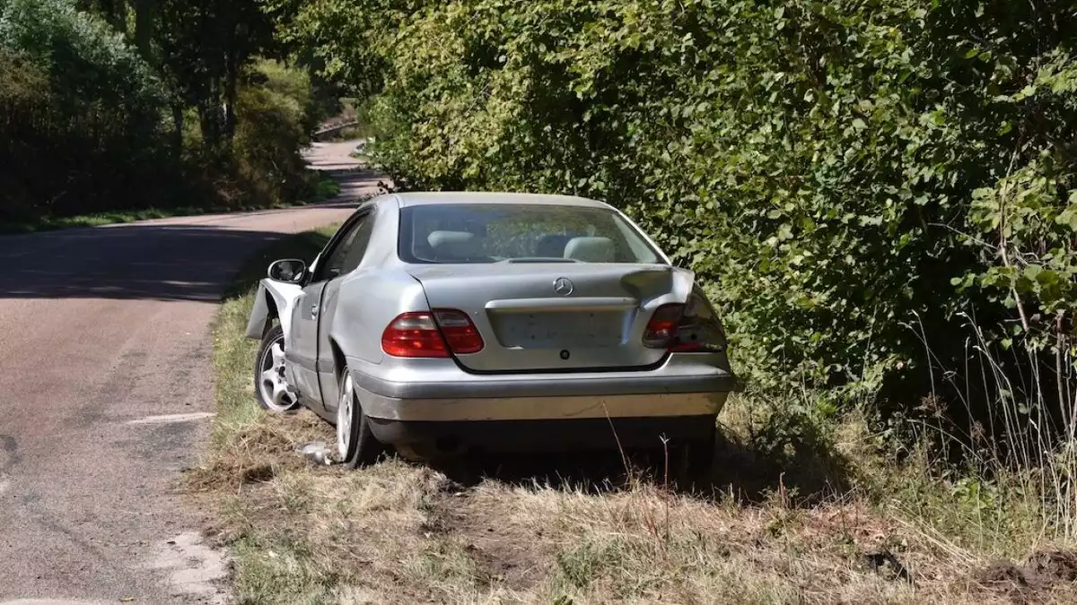 Imatge d'un cotxe abandonat a la vora d'un camí rural.