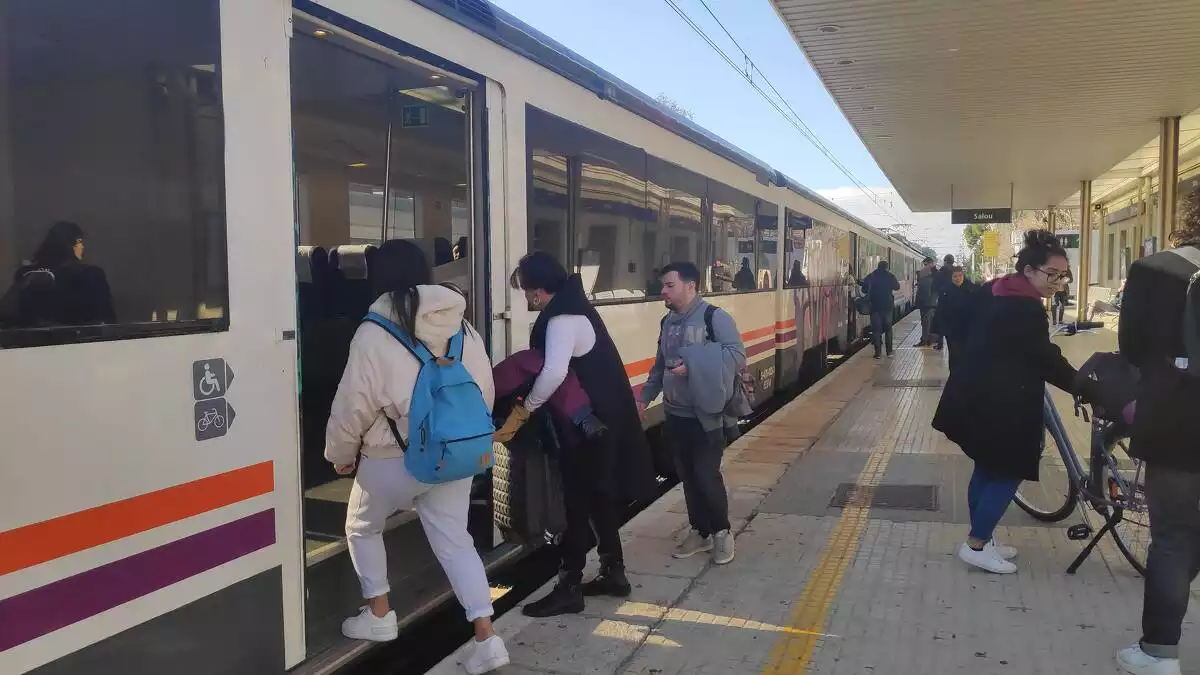 Passatgers pujant a un tren a l'Estació de Salou.