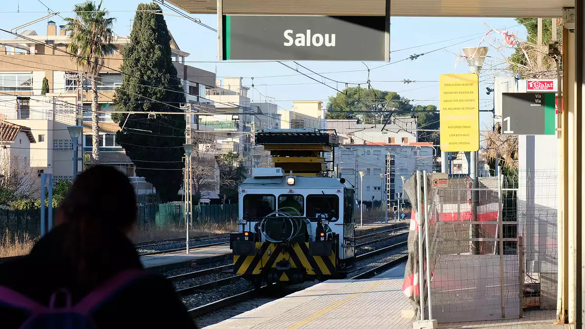 Una màquina d'Adif circula per les vies al costat de l'Estació de tren antiga de Salou.