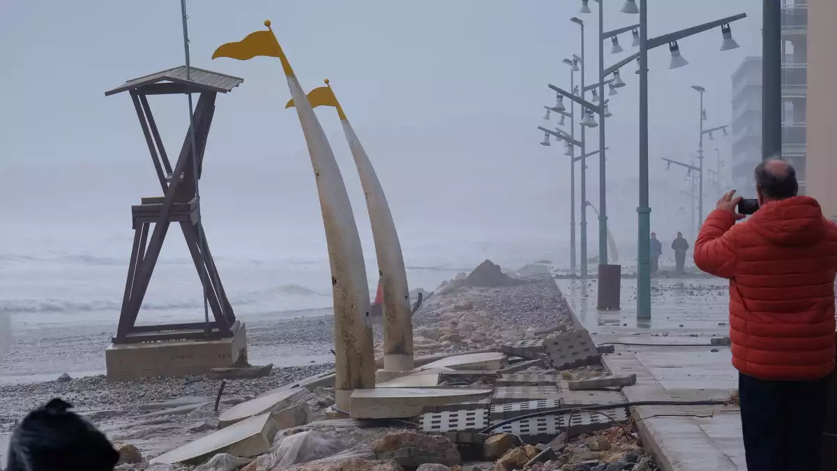 Un home fa una fotografia de les destrosses ocasionades pel temporal Glòria a la Pineda.