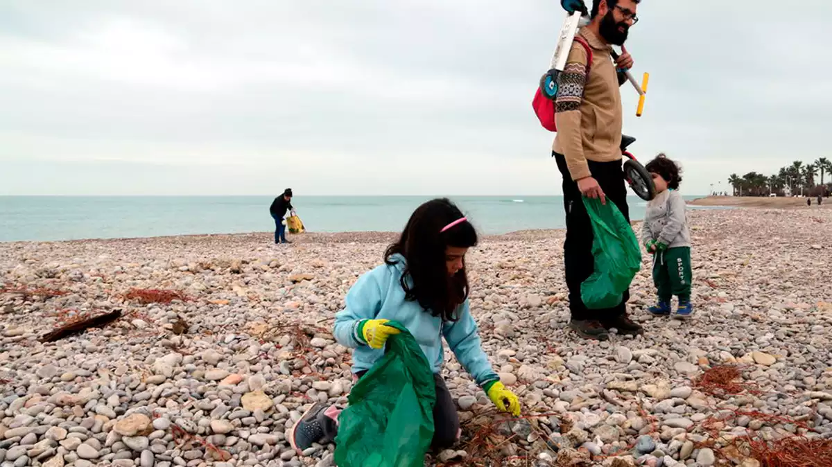 Pla obert d'una família que han han participat en la neteja de les platges de les Cases d'Alcanar després del temporal Glòria.