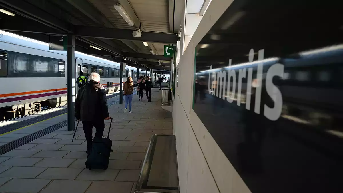 Un usuari del tren camina amb una maleta per una de les andanes de la nova estació de tren de Cambrils.