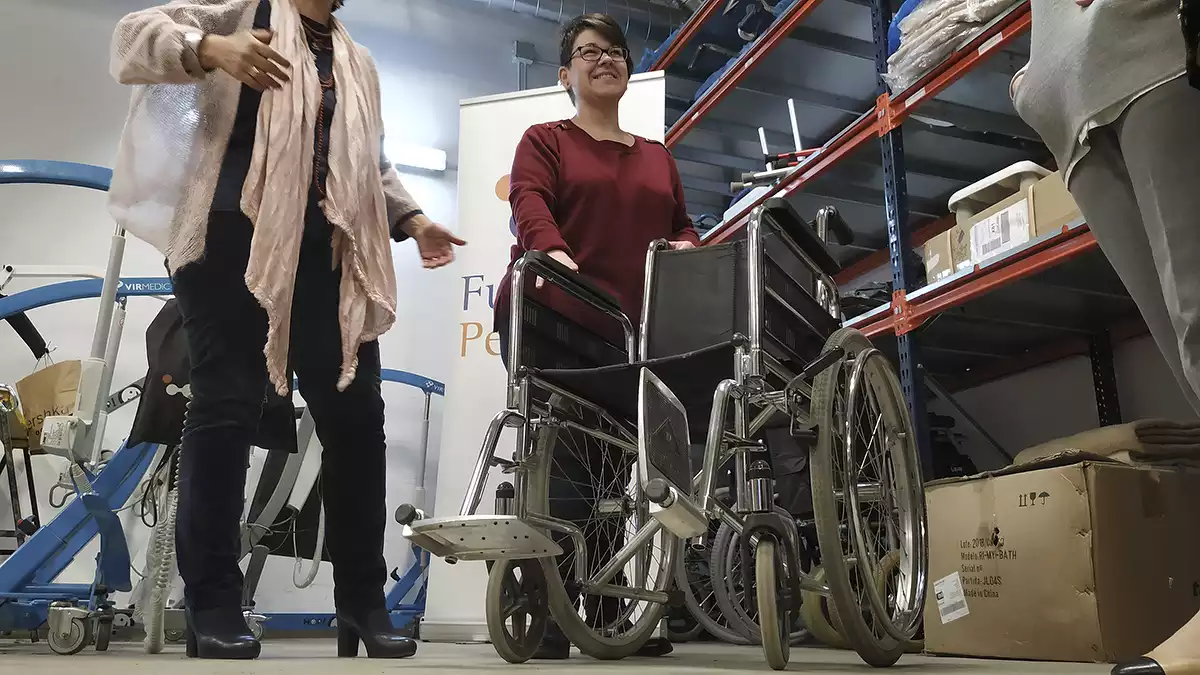 Elisabet Limones mostra una cadira de rodes al magatzem del Banc d'Ajudes Tècniques