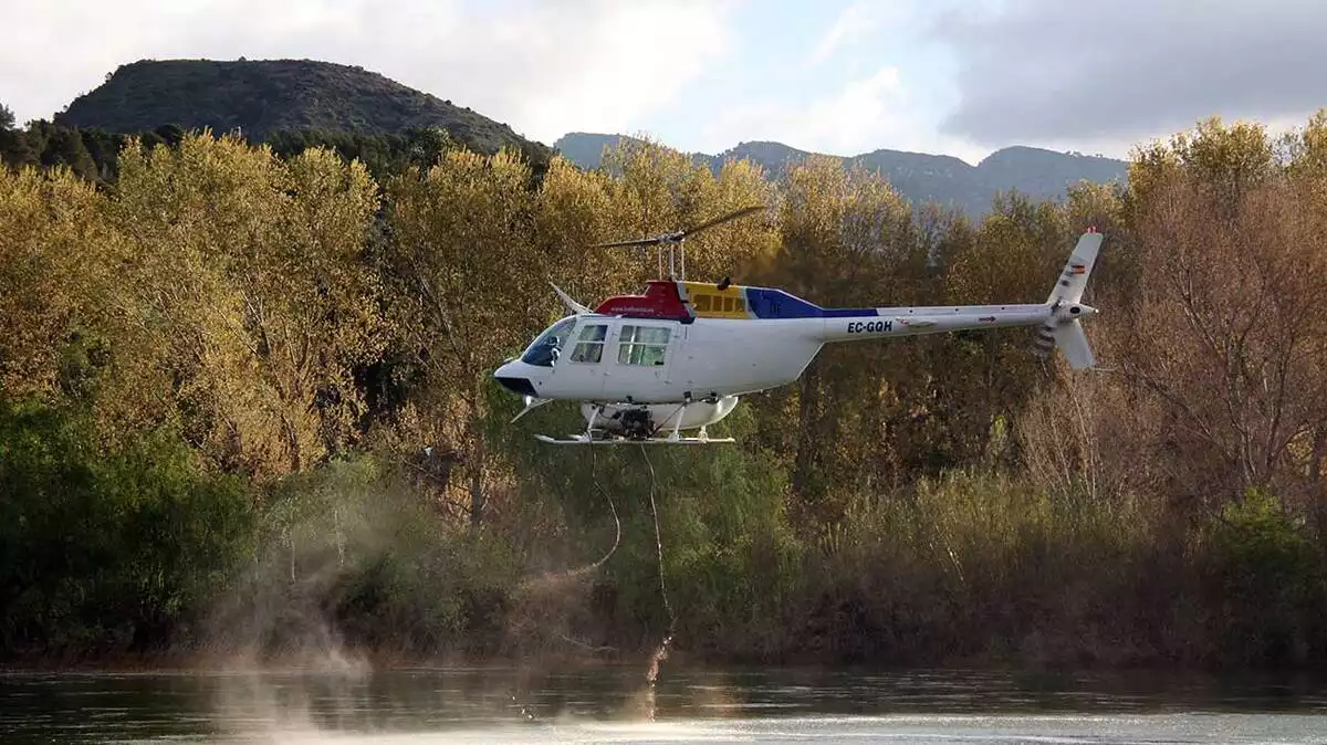 Un helicòpter buidant la càrrega d'insecticida biològic BTI al riu Ebre