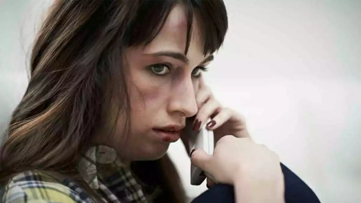 Una dona, víctima de violència masclista, fent una trucada per telèfon