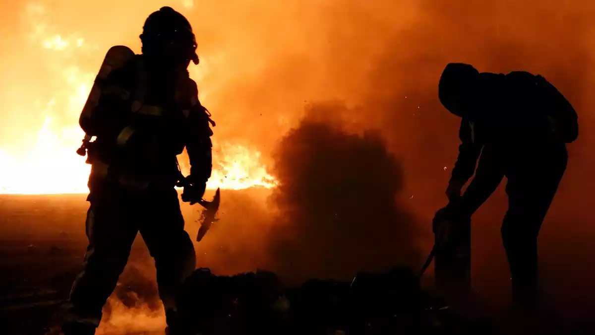 Una parella dels Bombers de la Generalitat treballant en un incendi