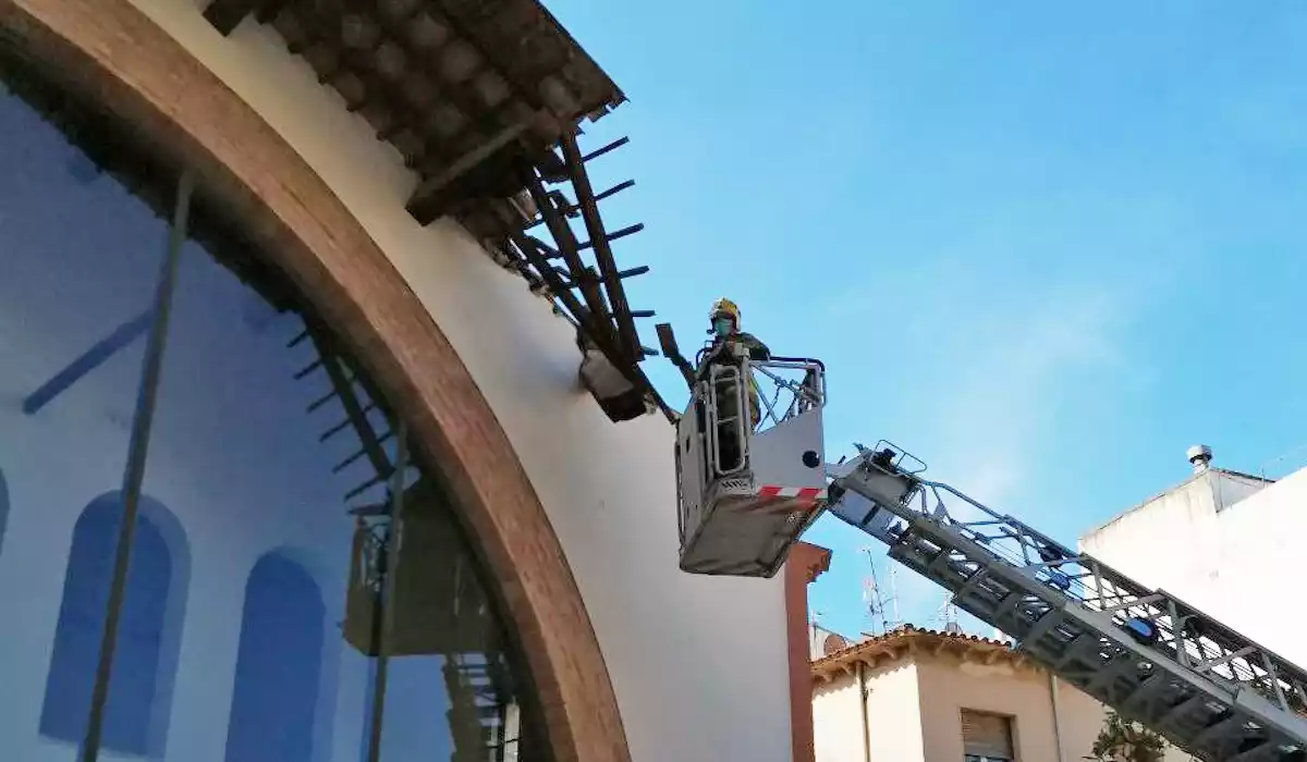 Imatge d'un bomber duent a terme el sanejament de la teulada del celler-cooperativa de Cambrils