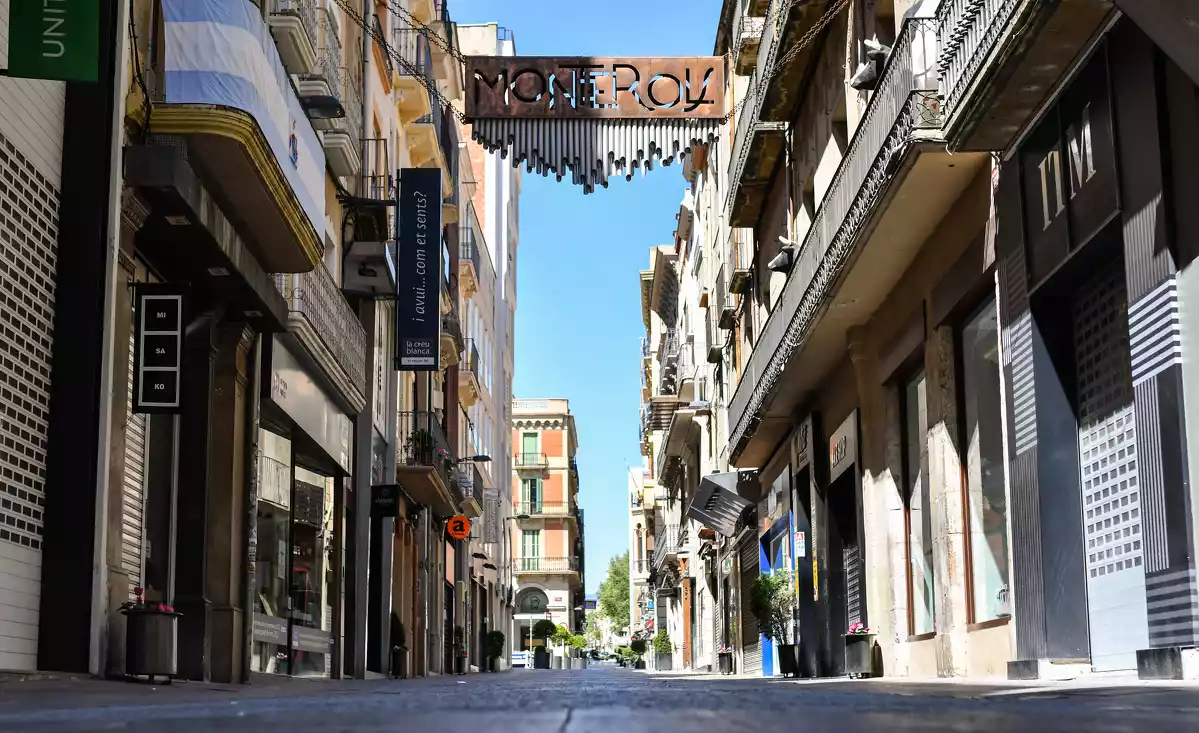 El carrer Monterols de Reus, buit i amb les botiges tancades durant l'estat d'alarma