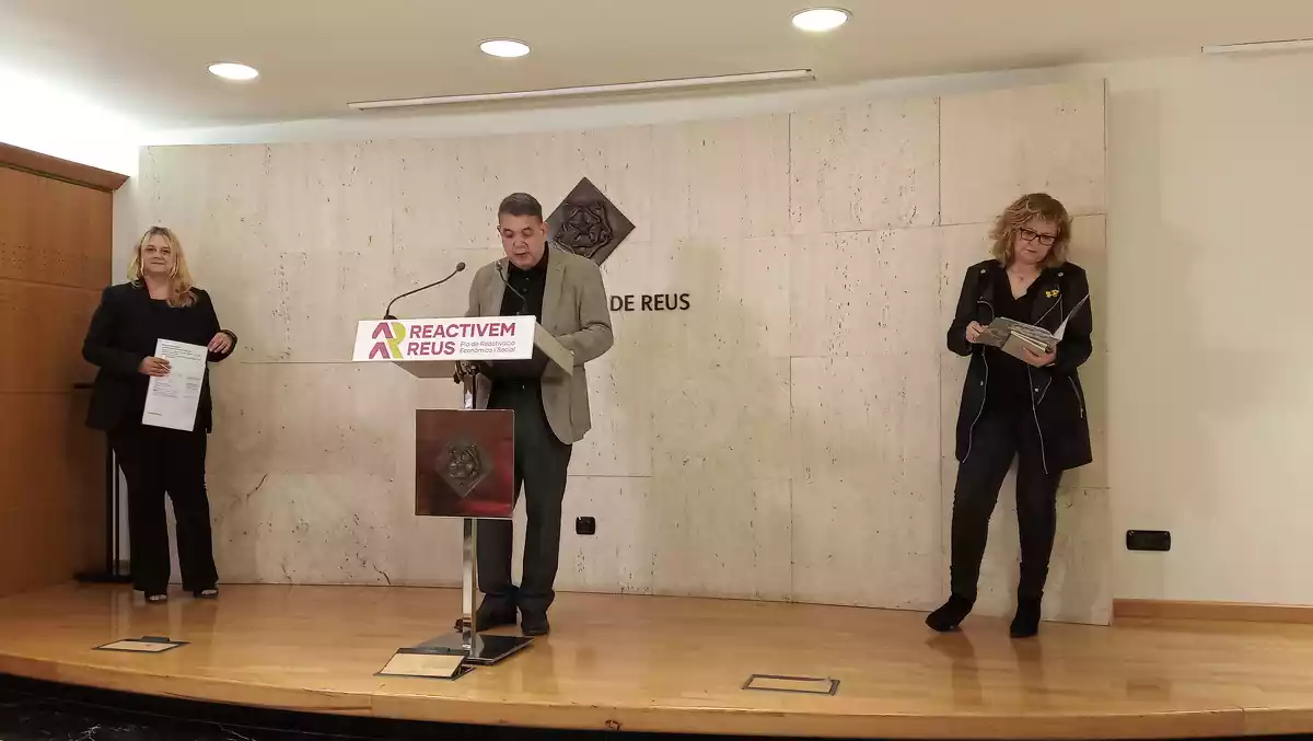 Montserrat Caelles, Carles Prats i Teresa Pallarès dempeus a la sala de premsa de l'Ajuntament de Reus