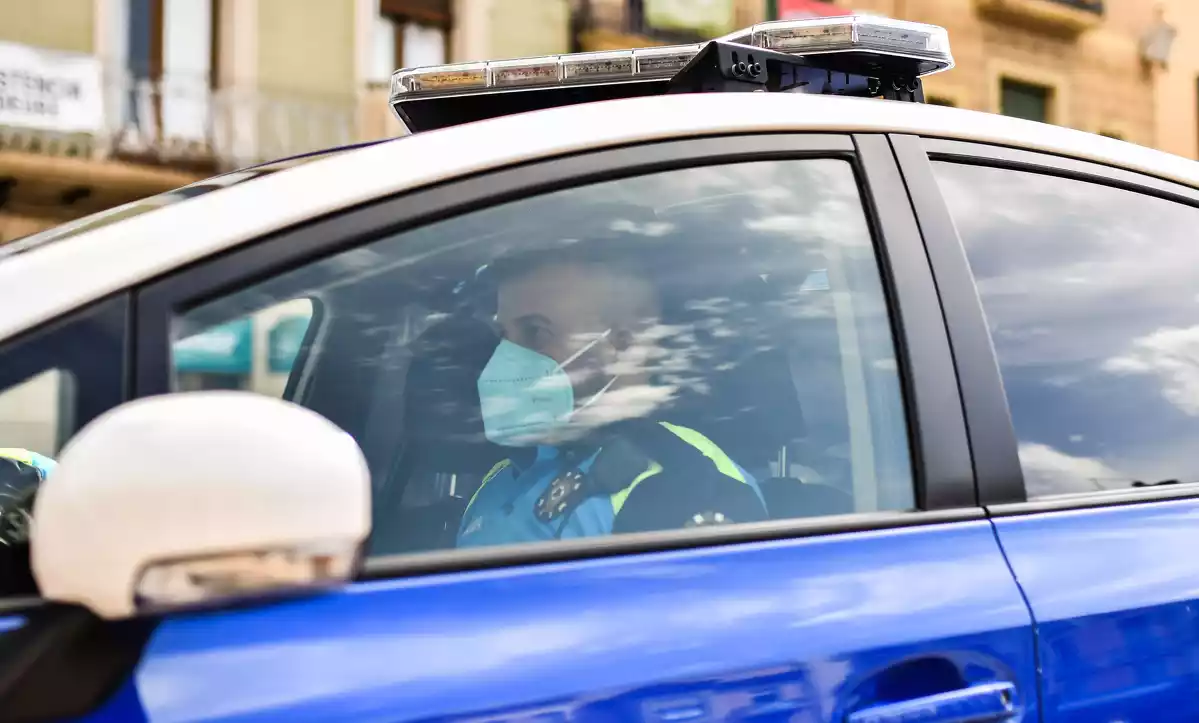 Un agent de la Guàrdia Urbana de Reus dins d'un vehicle policial, amb mascareta