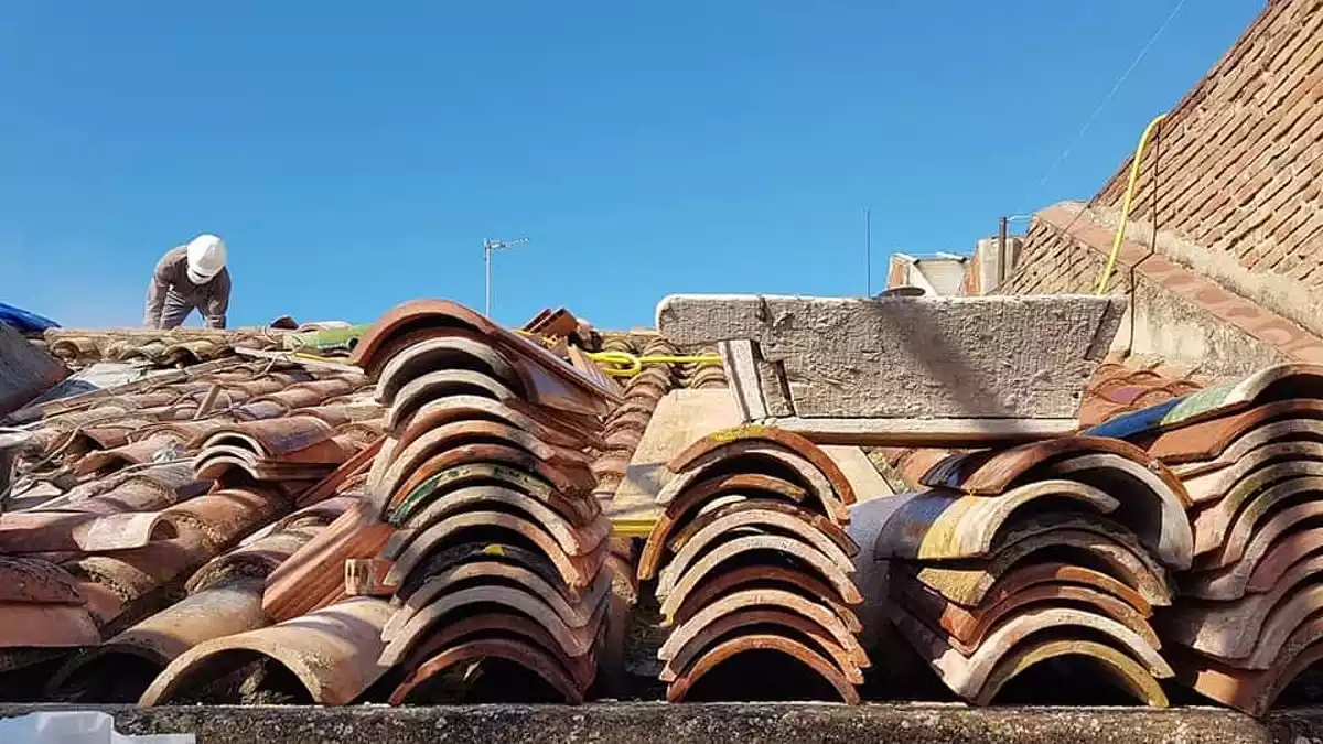 Teules apilades sobre la teulada de Casa Navàs, amb una pastera a sobre