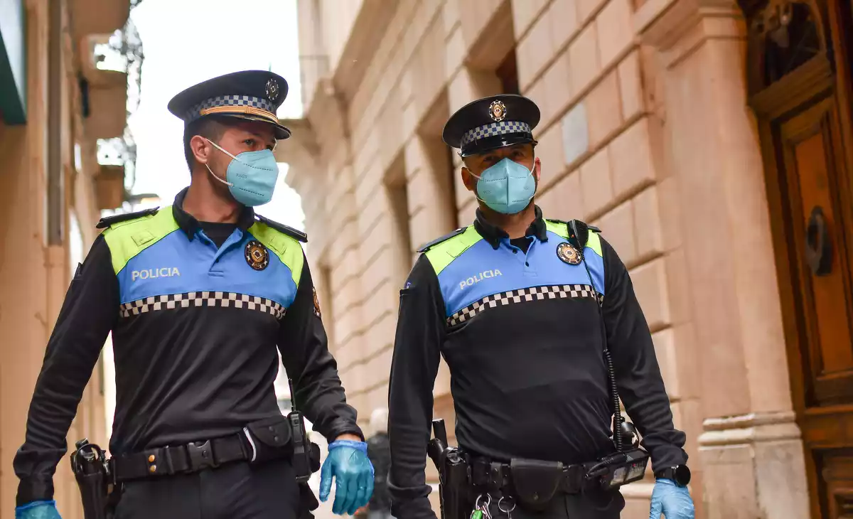 Dos agents de la Guàrdia Urbana de Reus patrullant pel carrer, amb guants i mascareta