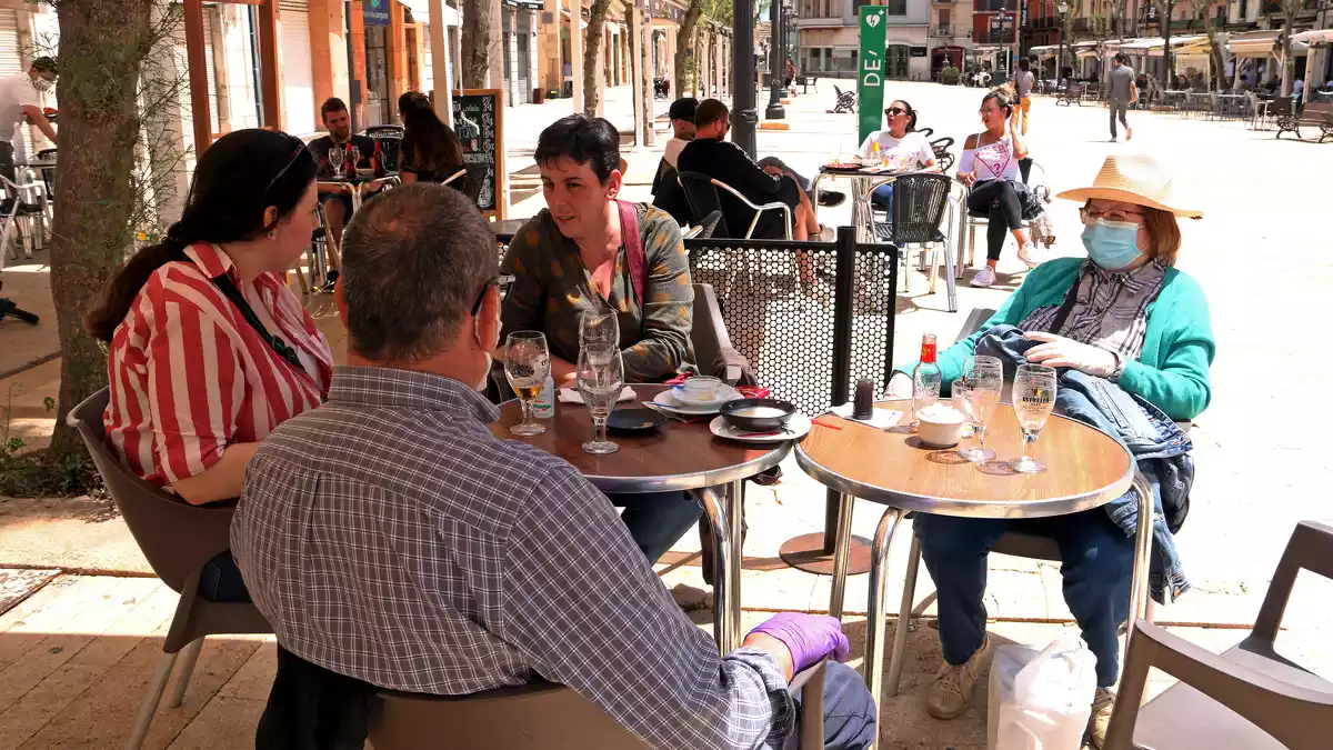 Pla obert d'una família consumint en una terrassa de la plaça de la Font de Tarragona en el primer dissabte de la fase 1