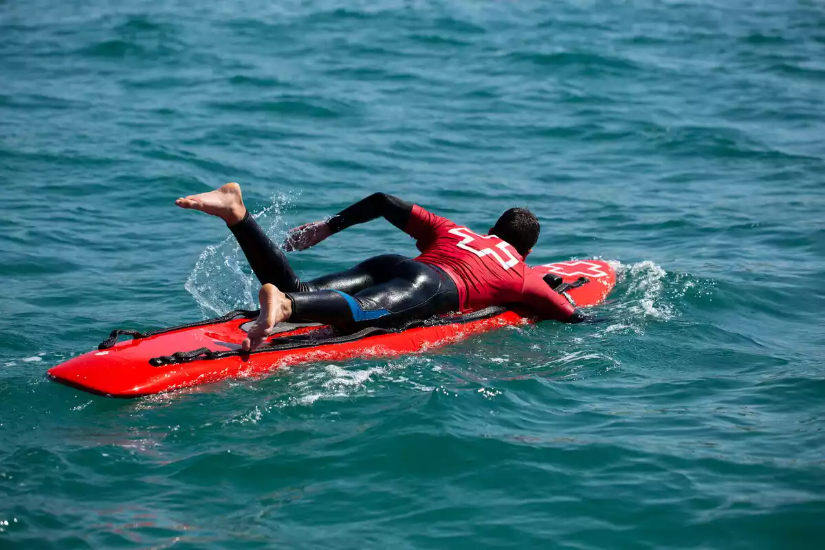 Pla obert d'un dels aspirants dins l'aigua fent una de les proves de selecció de la Creu Roja per ser socorrista.