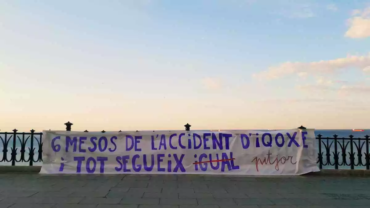 Cartell de la CUP penjat al Balcó del Mediterrani: «Sis mesos de l'accident d'IQOZE i tot segueix pitjor»