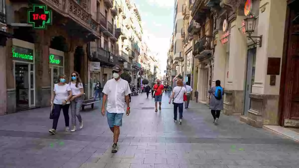 Imatge de diversos ciutadans passejant amb mascareta pel centre de Reus