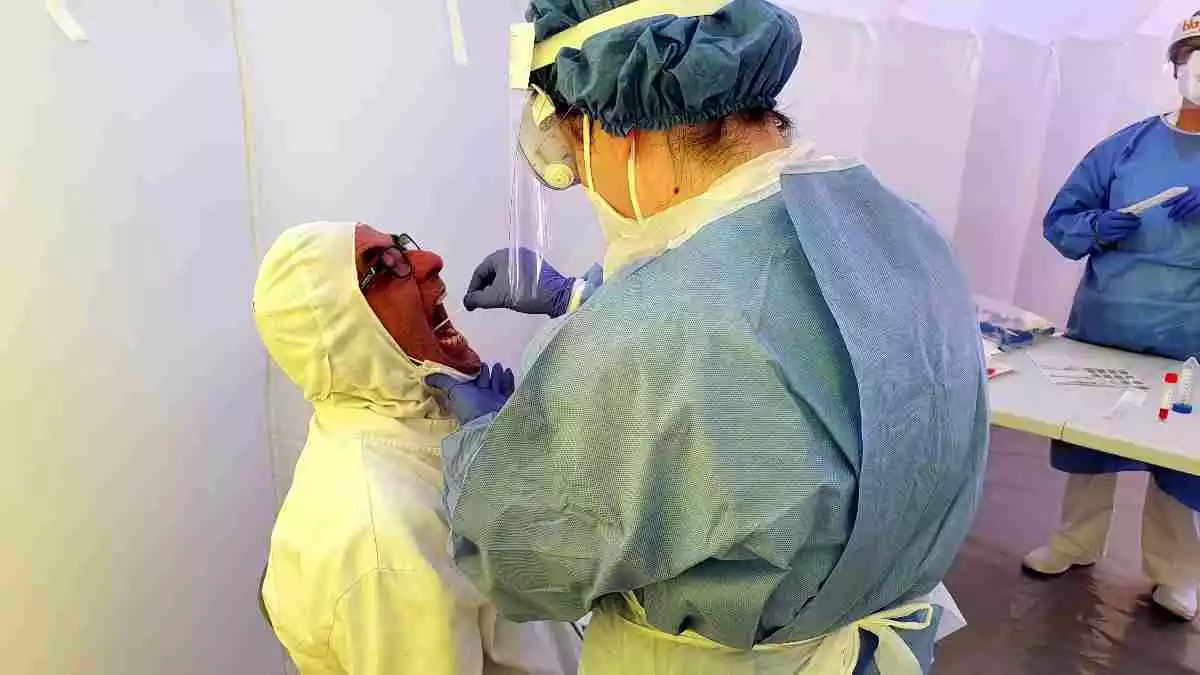 Imatge d'una sanitària realitzant un test PCR a un home