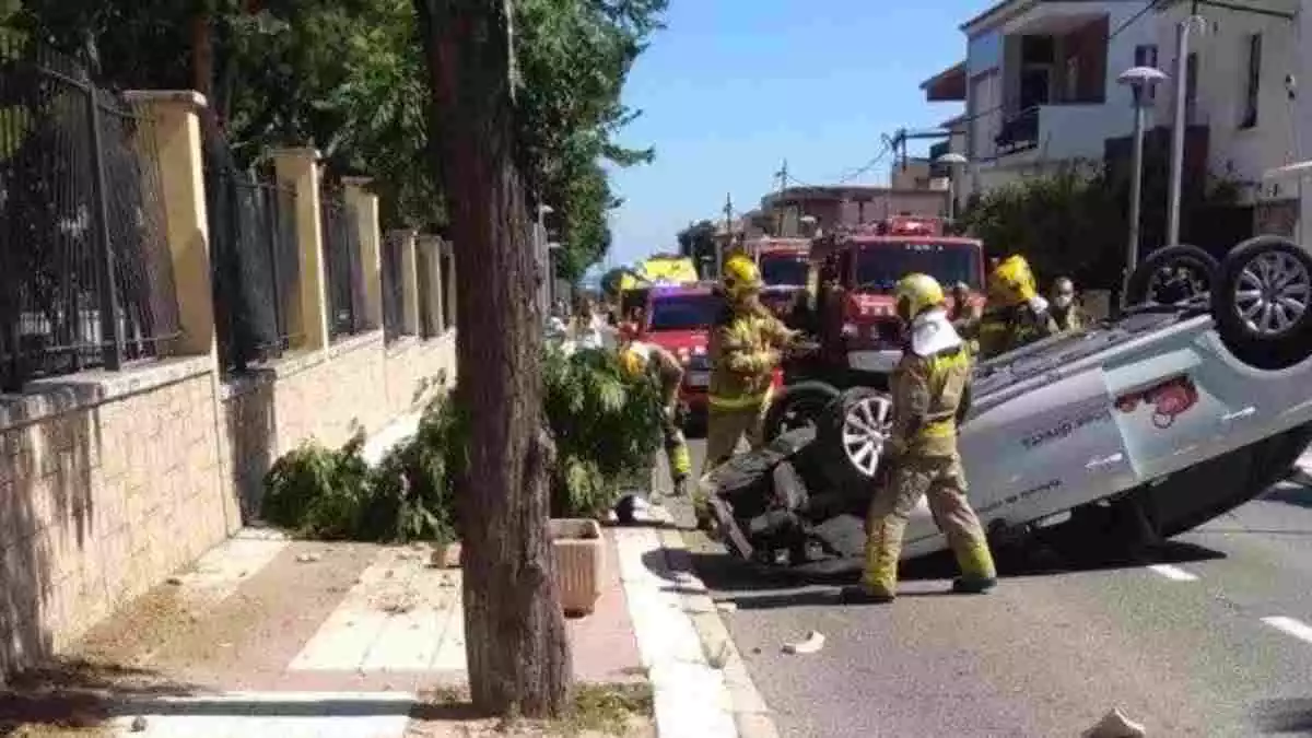 Els Bombers de la Generalitat treballant en un accident amb un cotxe bolcat al carrer Major de Constantí