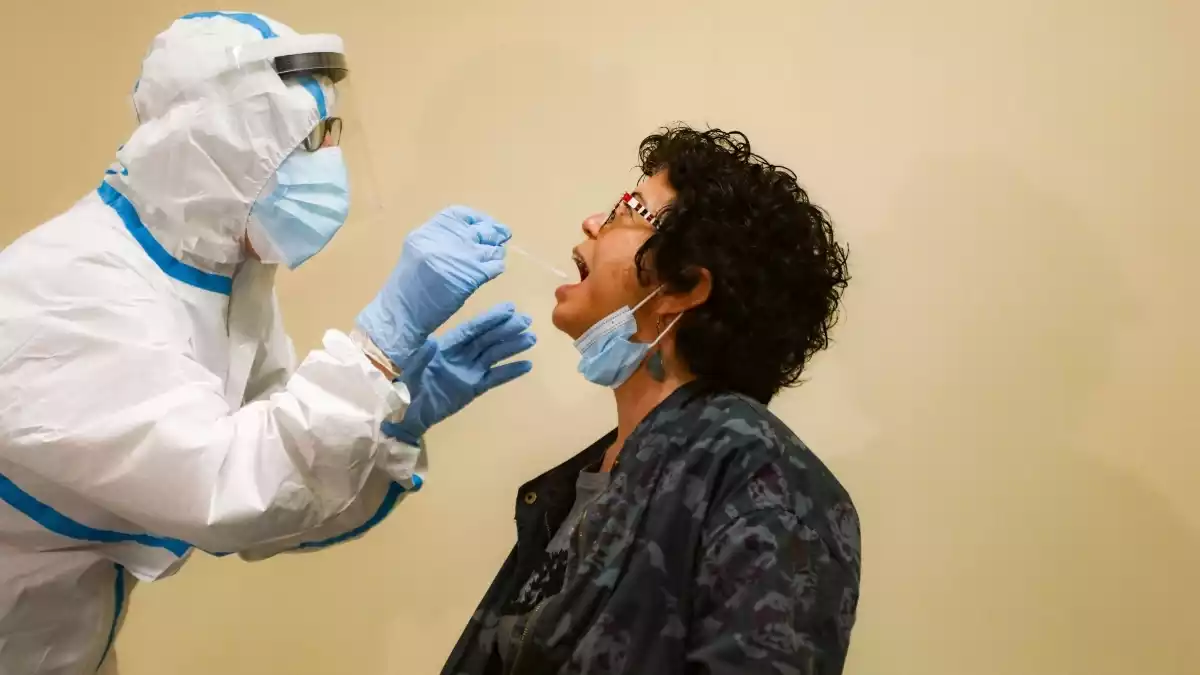 Una infermera fent la prova del coronavirus a una pacient