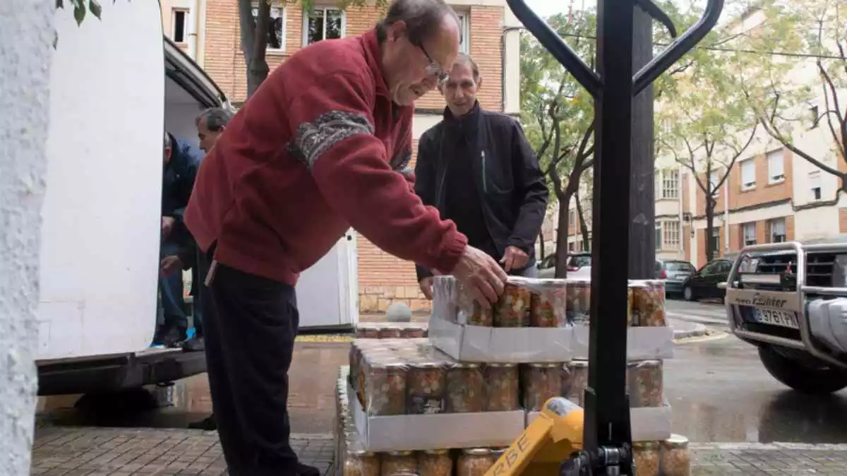 Imatge d'uns voluntaris del programa de gestió alimentària de Reus descarregant el gènere d'una furgoneta el Nadal de 2019