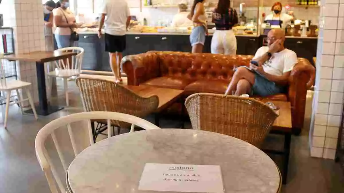 Pla mitjà d'una cafeteria de la plaça Mercadal de Reus, amb taules no disponibles per garantir la distància de seguretat.