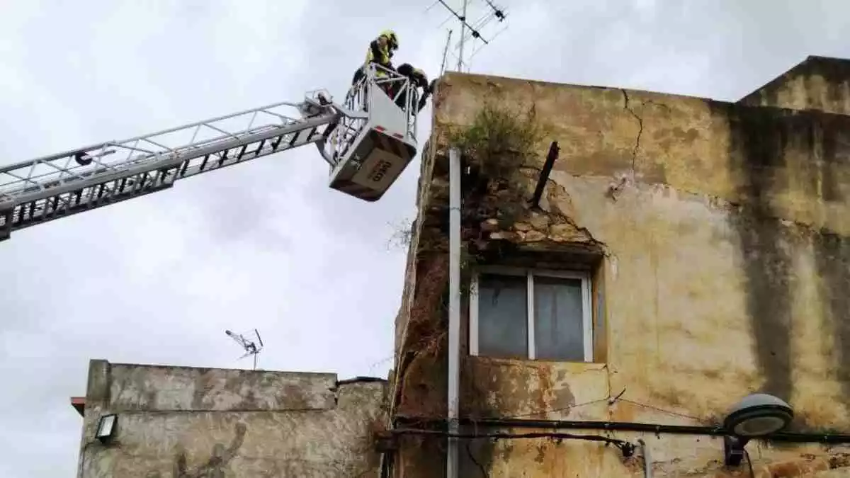 Els Bombers de la Generalitat treballen en un despreniment a la façana d'un edifici a la Pobla de Montornès