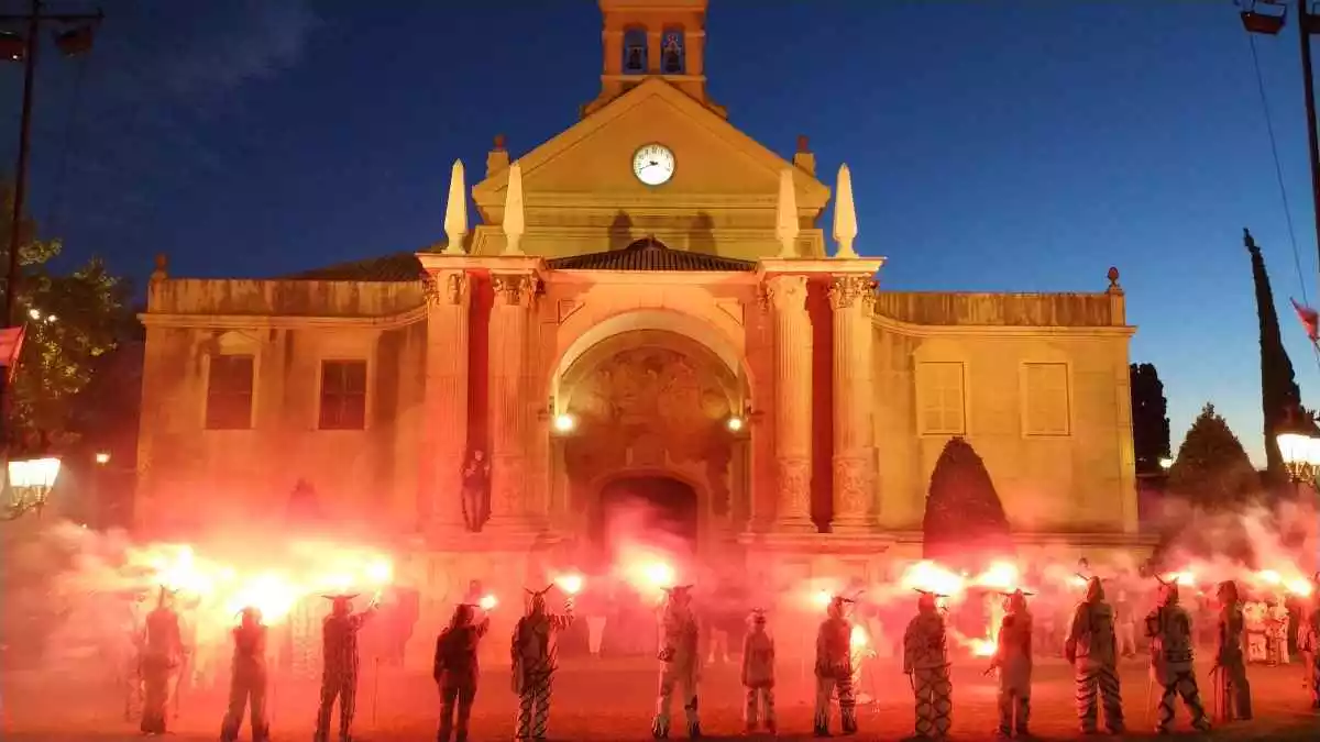 Els Diables de Reus encenent simuladors vermells davant del Santuari de Misericòrdia