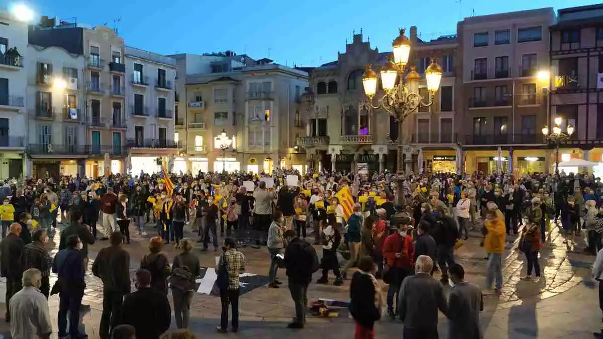 Imatge de la plaça del Mercadal amb la concentració al fons i els responsables de les entitats en primer pla