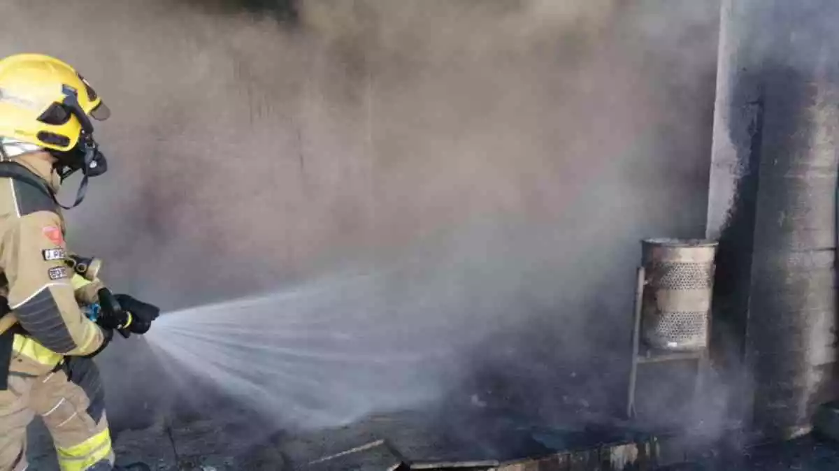 Imatge d'un bomber apagant l'incendi en un bar de l'Hospitalet de l'Infant