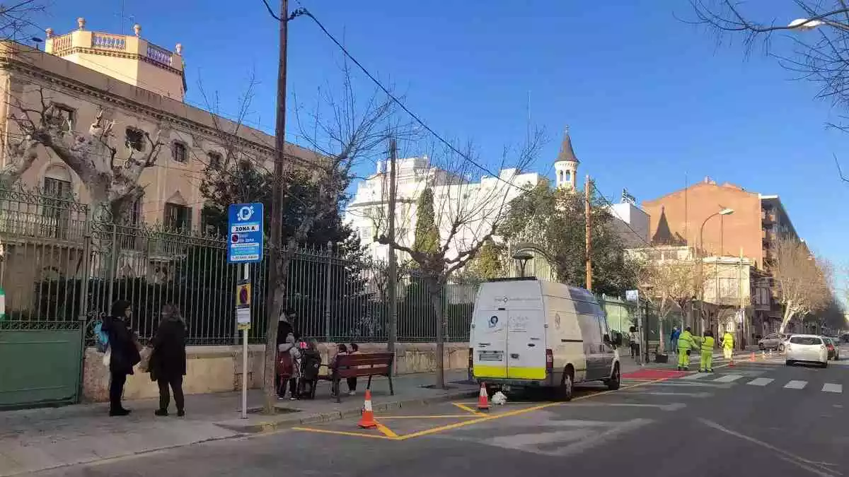 La Brigada Municipal pintant l'espai reservat per deixar i recollir la canalla davant de l'escola Maria Cortina