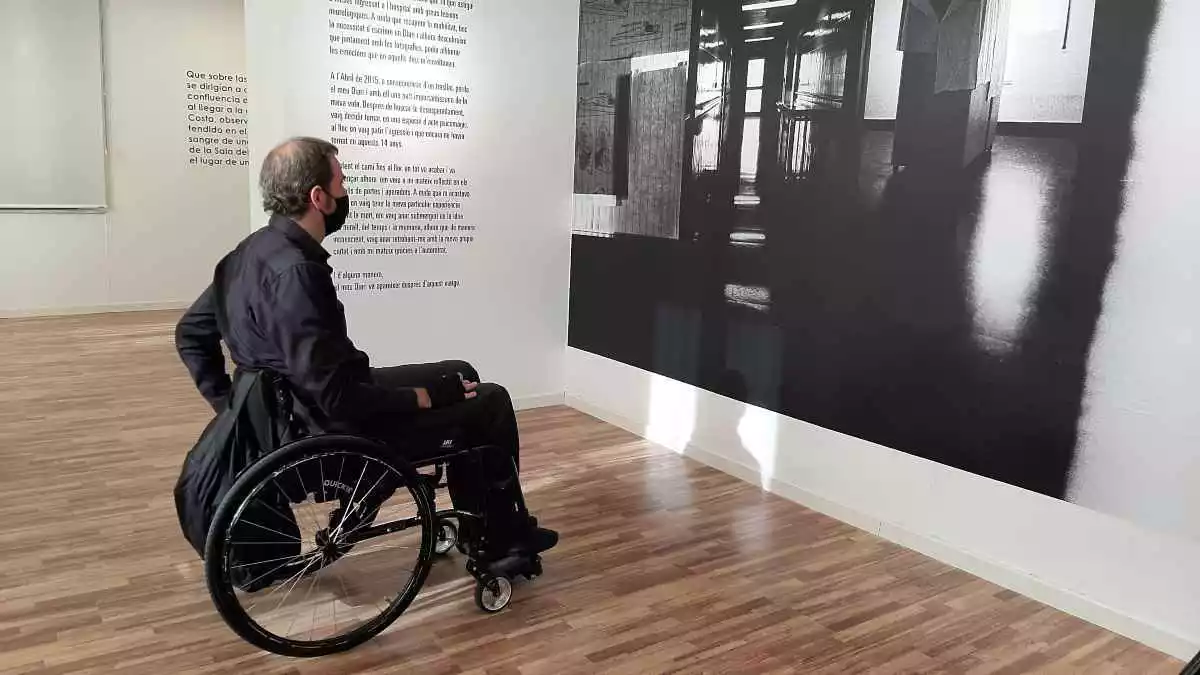 Agust Prats davant d'una de les fotografies de la seva exposició