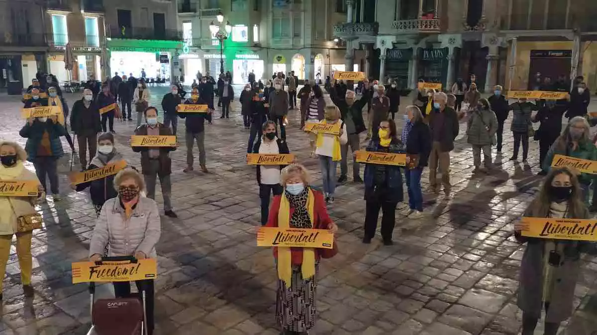 Diverses persones concentrades a la plaça del Mercadal de Reus amb cartells de «Llibertat»
