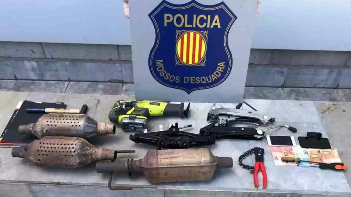Imtge dels tres catalitzadors de cotxe, diners en efectiu i diverses eines confiscats pels Mossos d'Esquadra