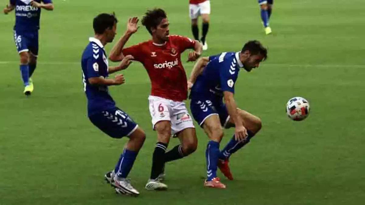 Lluita per la pilota entre tres jugadors de futbol