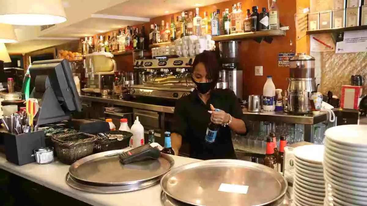 Pla mitjà de la barra del restaurant Capuccino de Tarragona, amb una de les treballadores