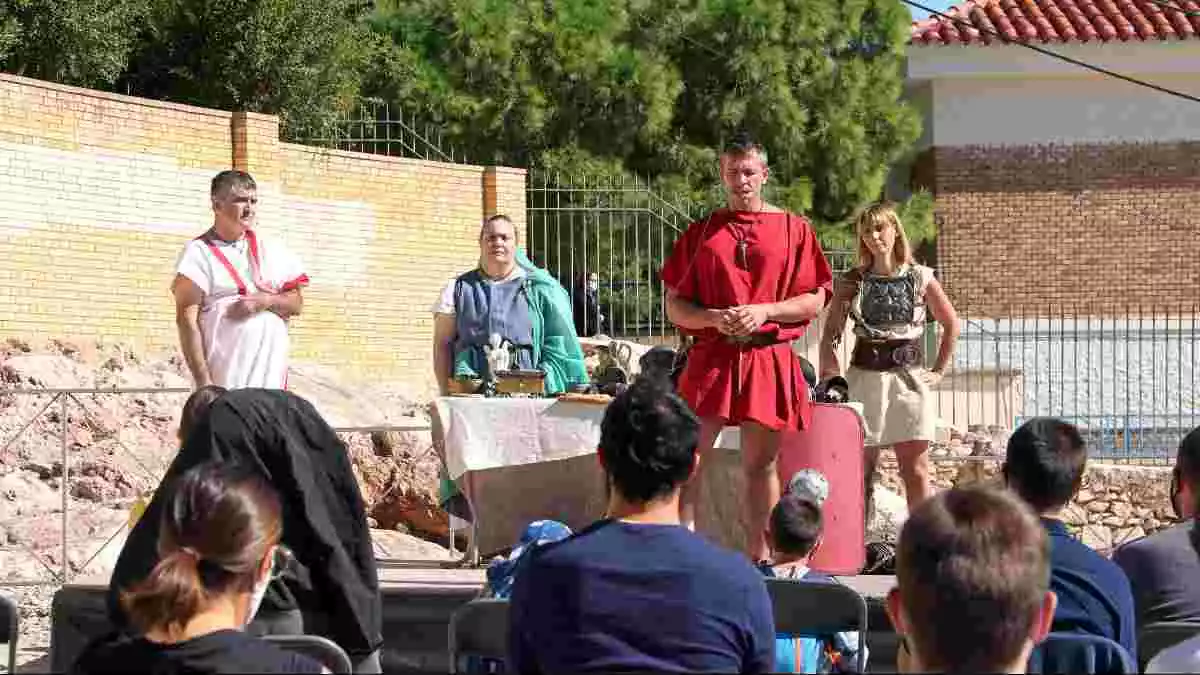 Pla obert dels personatges romans i del públic d'esquenes que han participat en una de les activitats organitzades per Tarraco Viva que s'ha fet a l'amfiteatre romà de Tarragona.