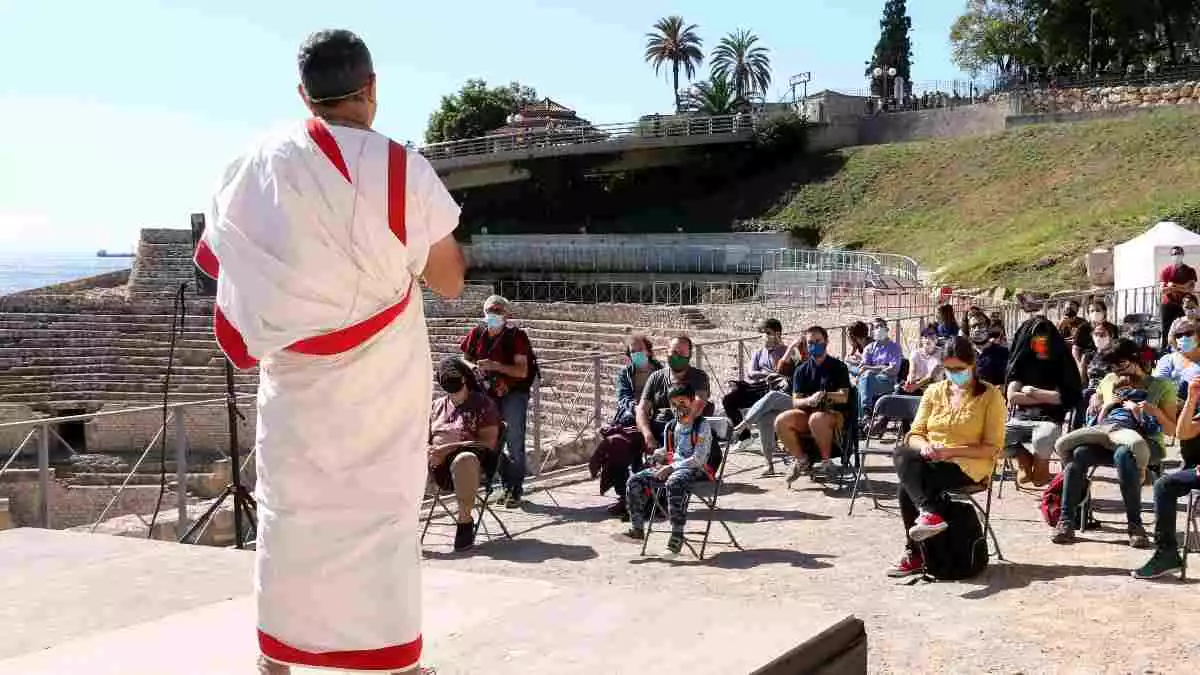 Pla obert d'un dels personatges romans i del públic que han participat en una de les activitats organitzades per Tarraco Viva que s'ha fet a l'amfiteatre romà de Tarragona.