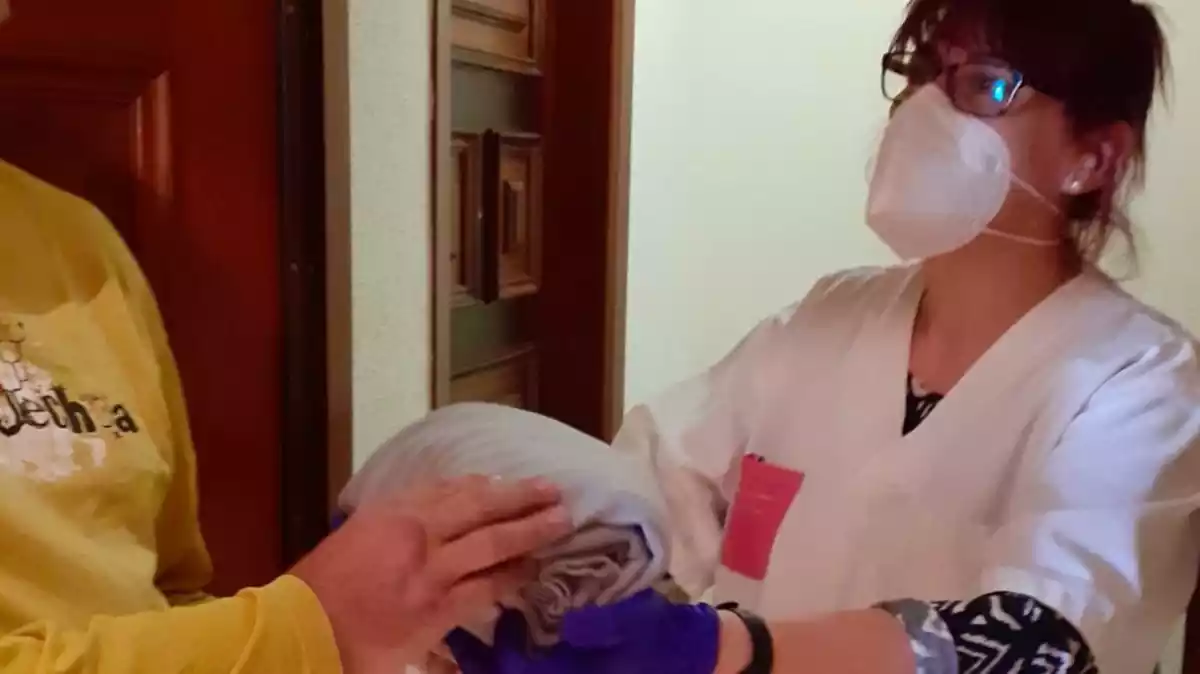 Una dona entregant mantes per a la campanya de l'Arc Serveis Assistencials SL discover
