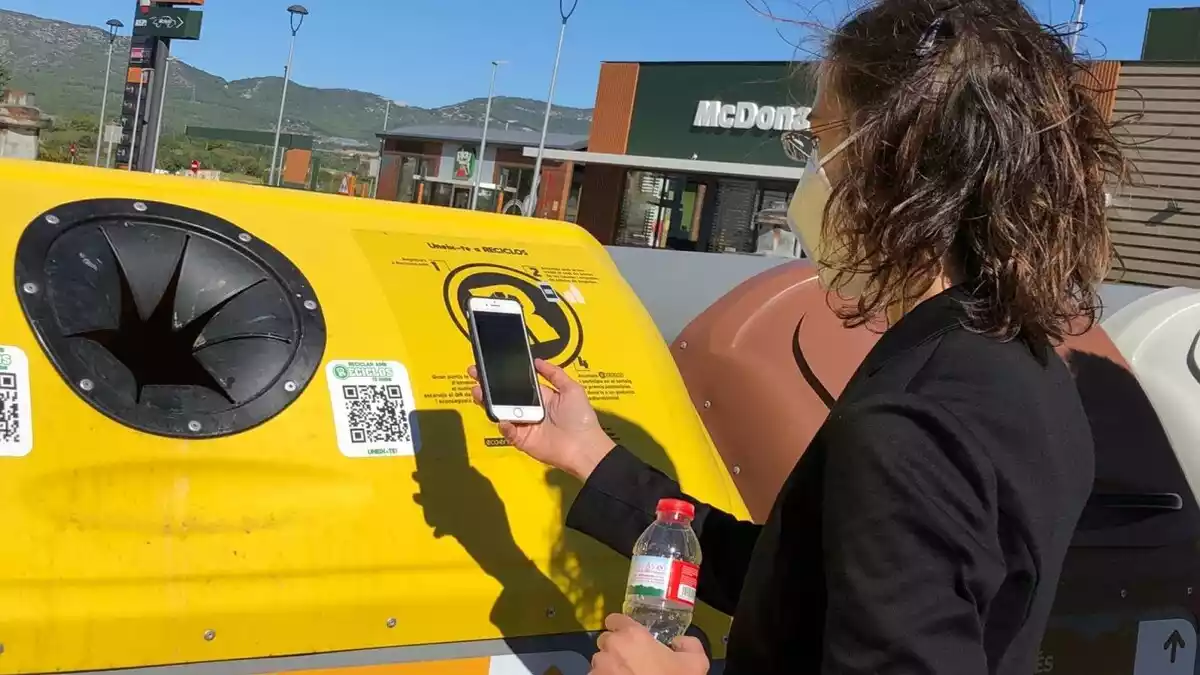 Una usuària escanejant en codi QR d'un contenidor de Valls