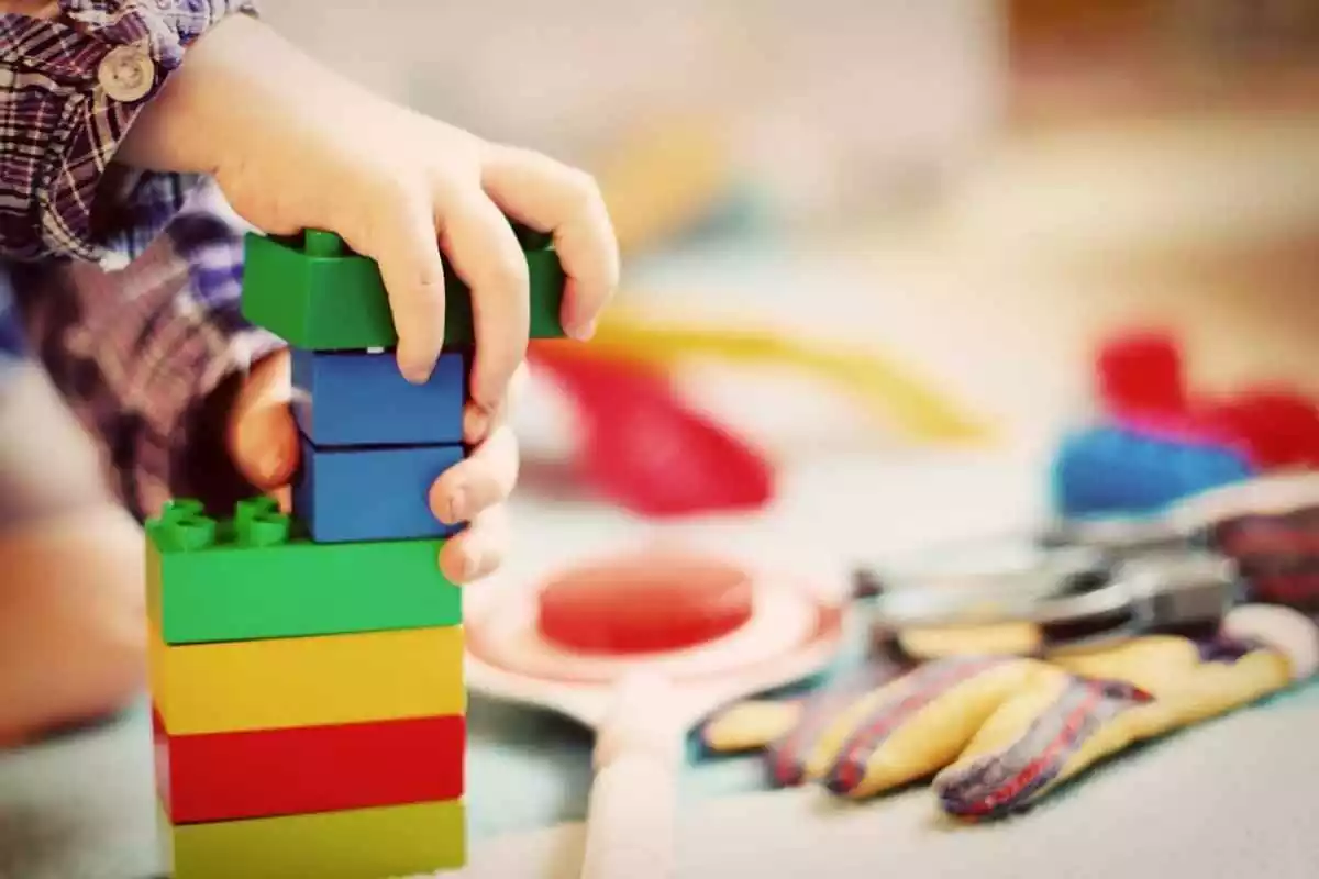 Imatge d'un nen/a jugant amb figures de colors