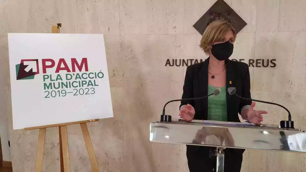 Noemí Llauradó a la sala de premsa de l'Ajuntament de Reus, amb un cartell del PAM al costat