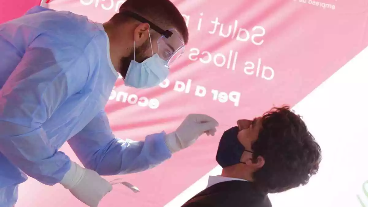 Personal sanitari pren mostres a un treballador del polígon de Sant Quirze del Vallès per fer un test d'antígen