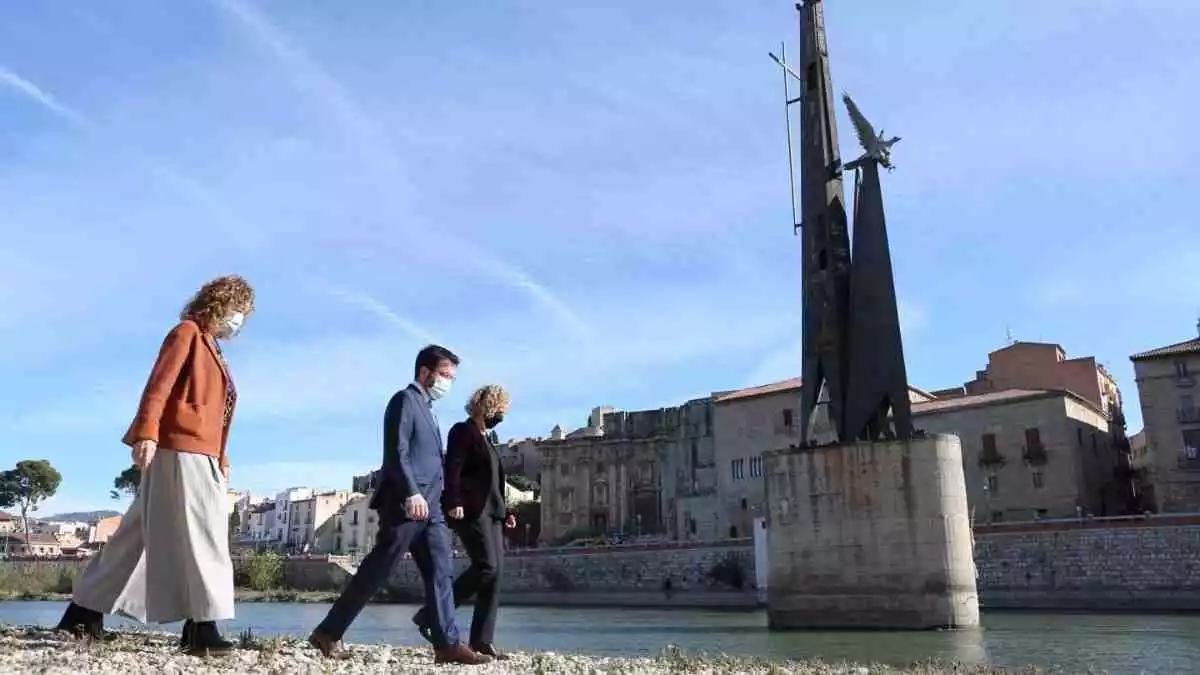 Pla general del vicepresident Pere Aragonès, la consellera Ester Capella i l'alcaldessa de Tortosa als peus del monument franquista, a la llera de l'Ebre.