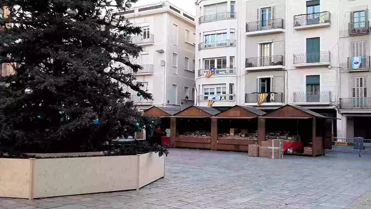 La plaça del Mercadal de Reus, amb l'arbre de Nadal al centre i quatre estands del mercat muntats