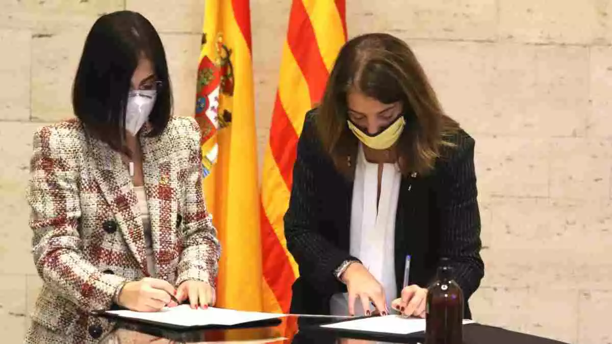 Pla mitjà de la ministra Carolina Darias i la consellera Meritxell Budó signant el conveni per pal·liar els efectes dels últims temporals