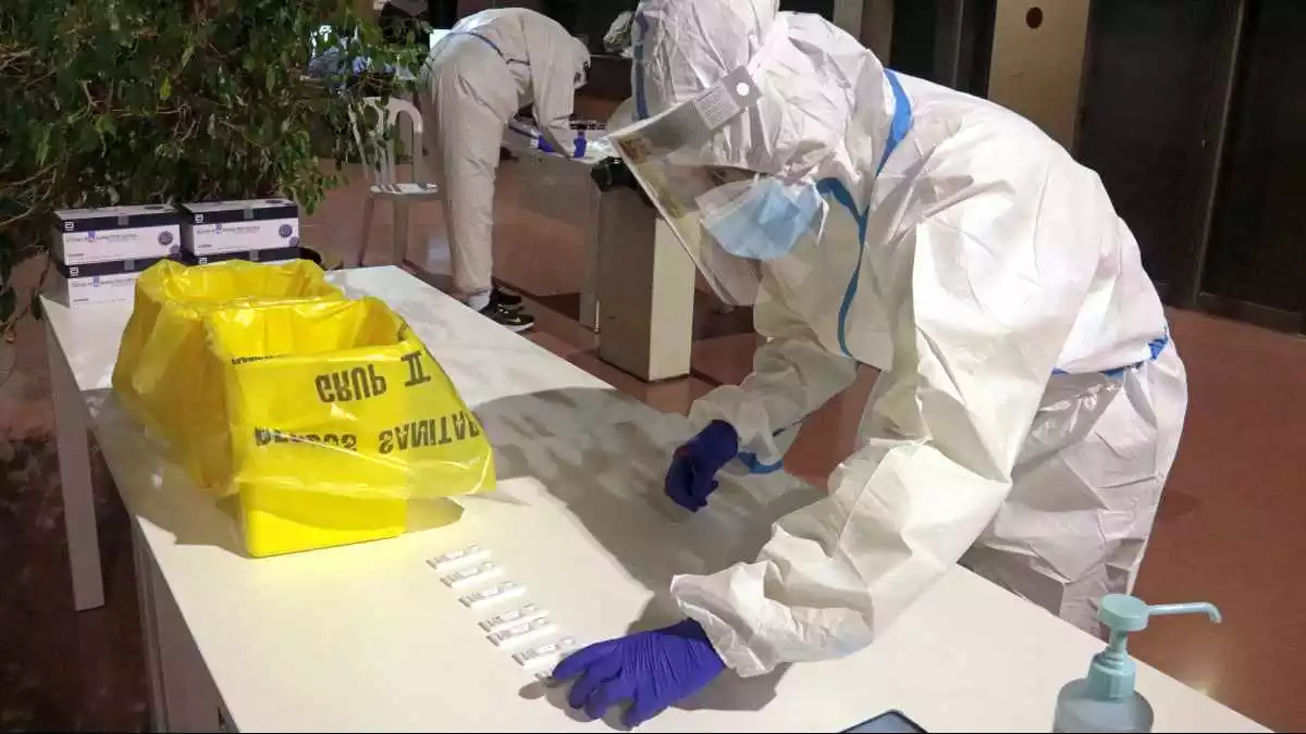 Un professional sanitari dipositant una mostra en un test d'antígens