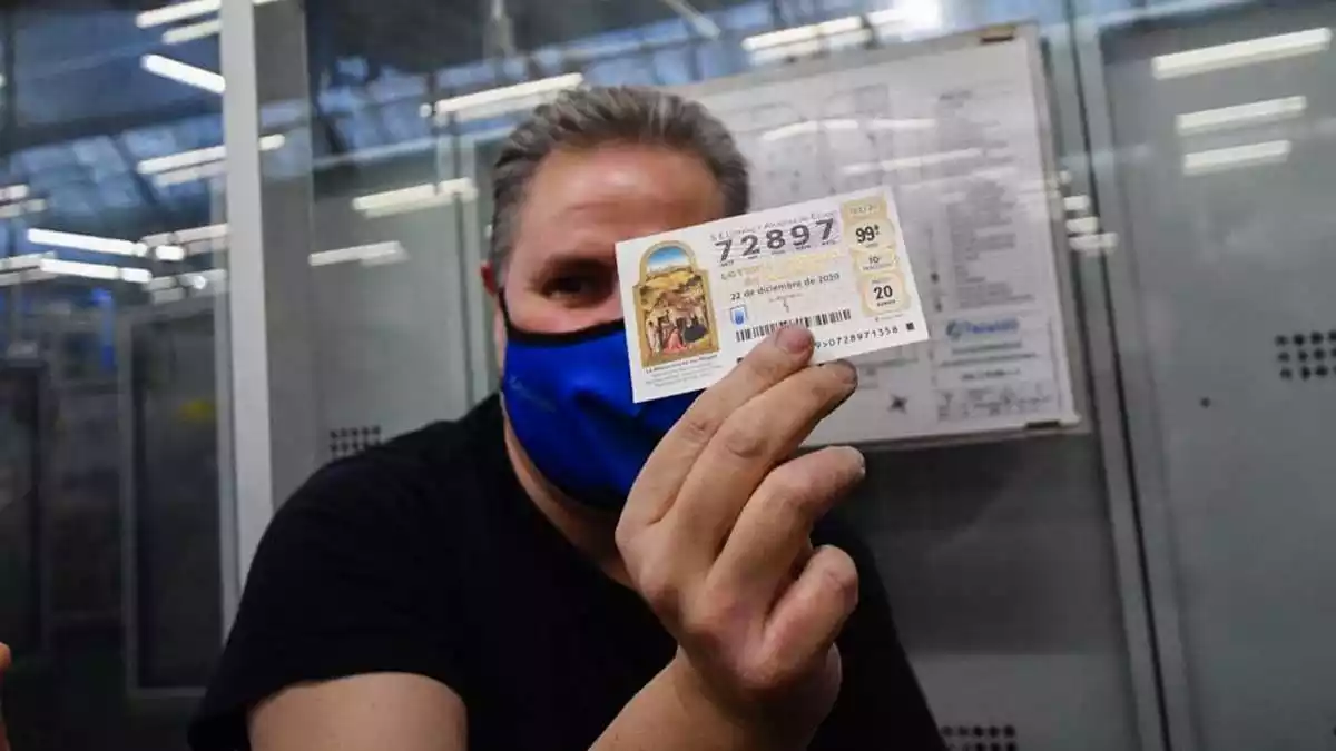 Un treballador d'Industrias Teixido ensenya el número premiat amb el 'Gordo', el 72897
