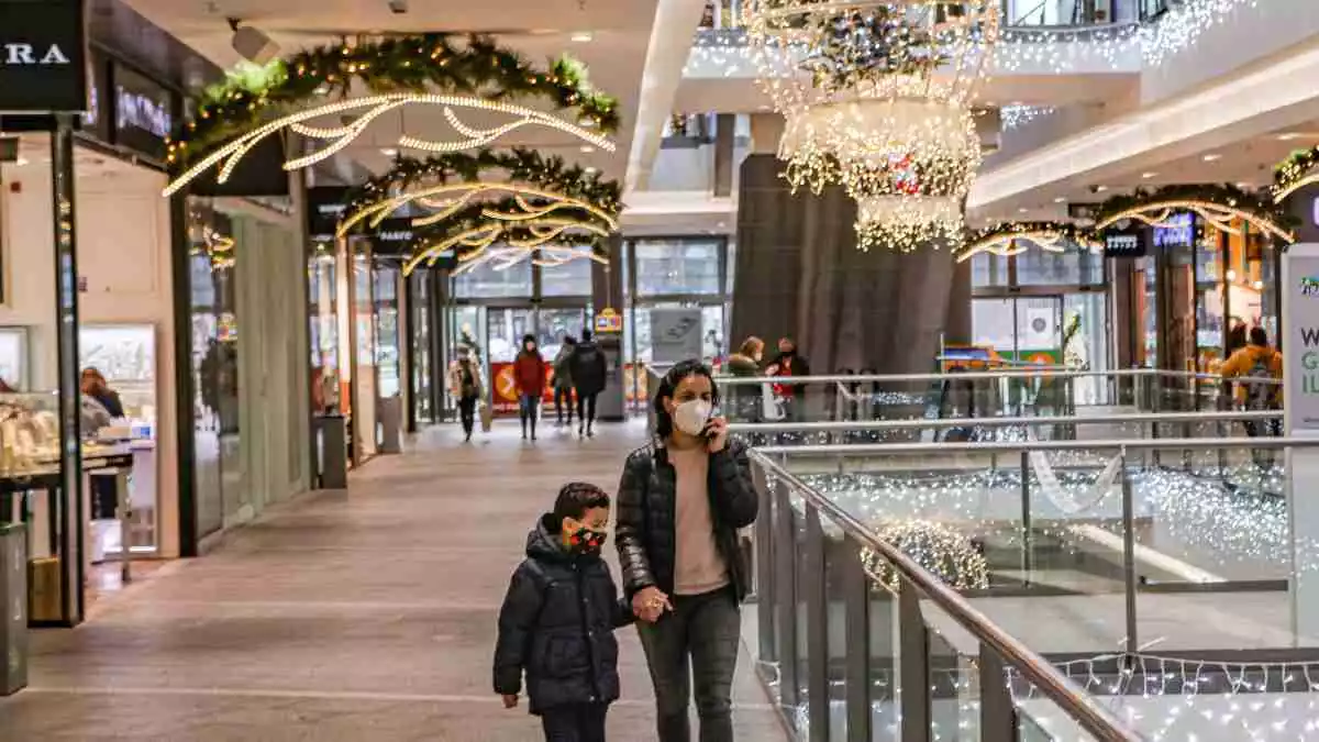 Una dona i un nen amb mascareta passejant per La Fira de Reus els dies previs a Nadal